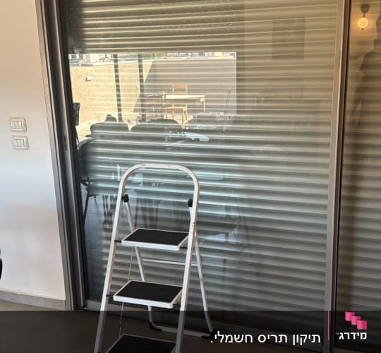 סולם מול תריסים סגורים במרפסת